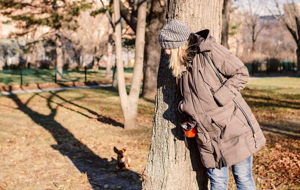 lady playing hide and seek in trees